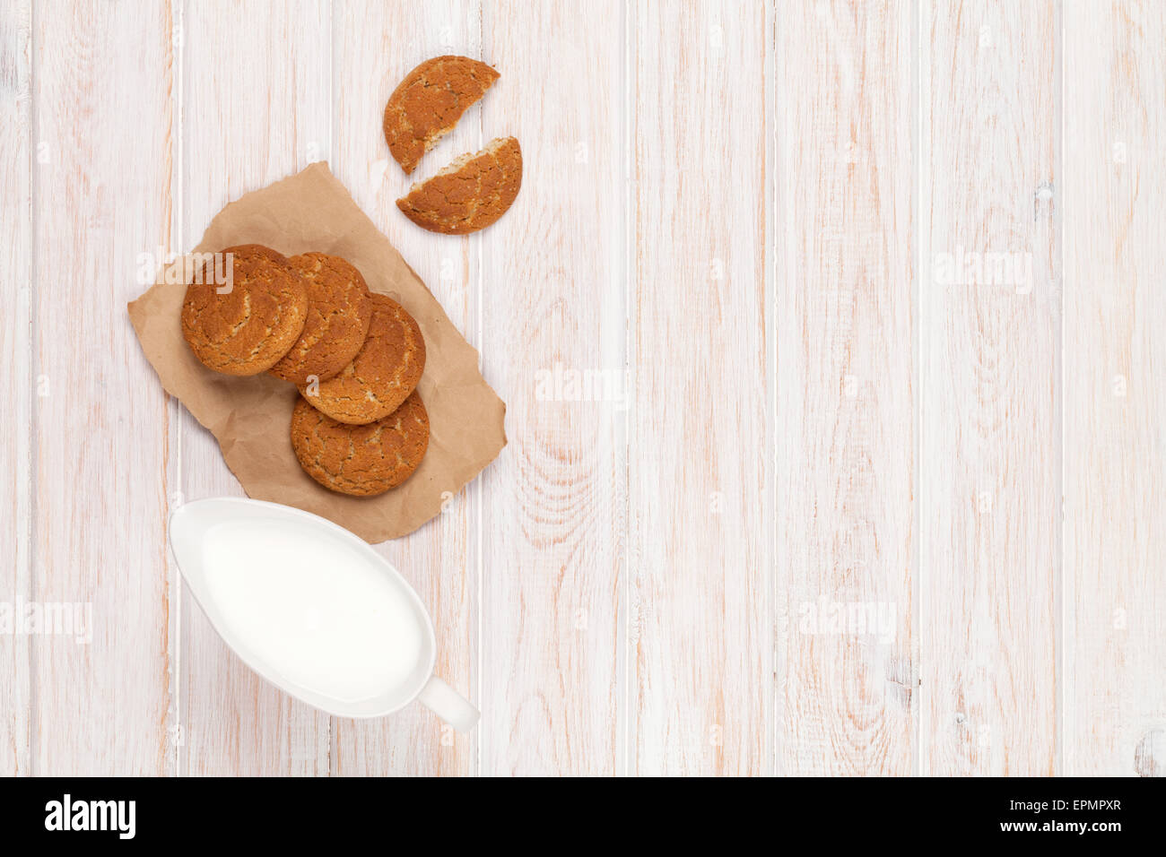 Brocca del latte e biscotti di panpepato su bianco tavolo in legno con spazio di copia Foto Stock