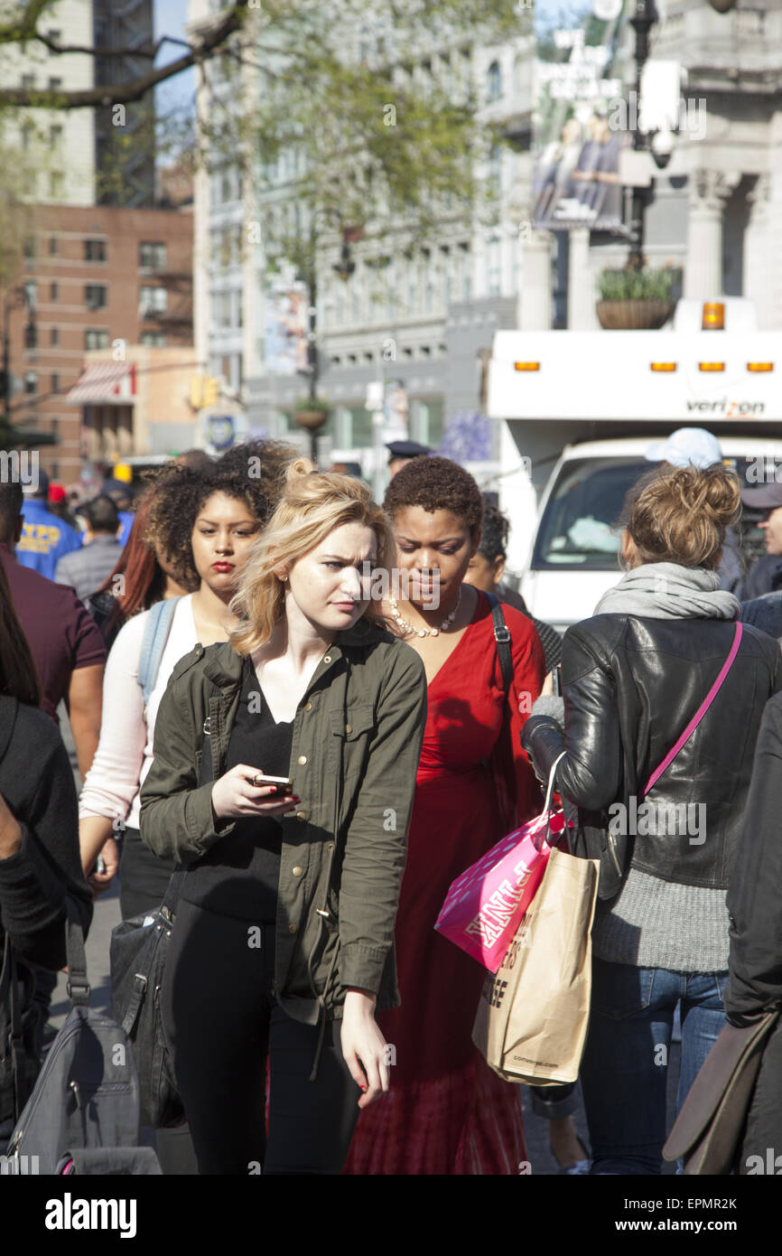 I giovani a piedi lungo il marciapiede affollato sulla quattordicesima st passati Union Square a Manhattan NYC. Foto Stock