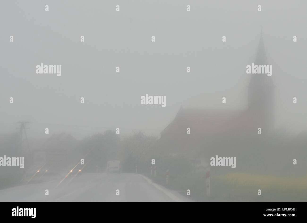 La città scompare nella nebbia e pioggia tempesta ed è difficile da guidare un'auto. Foto Stock