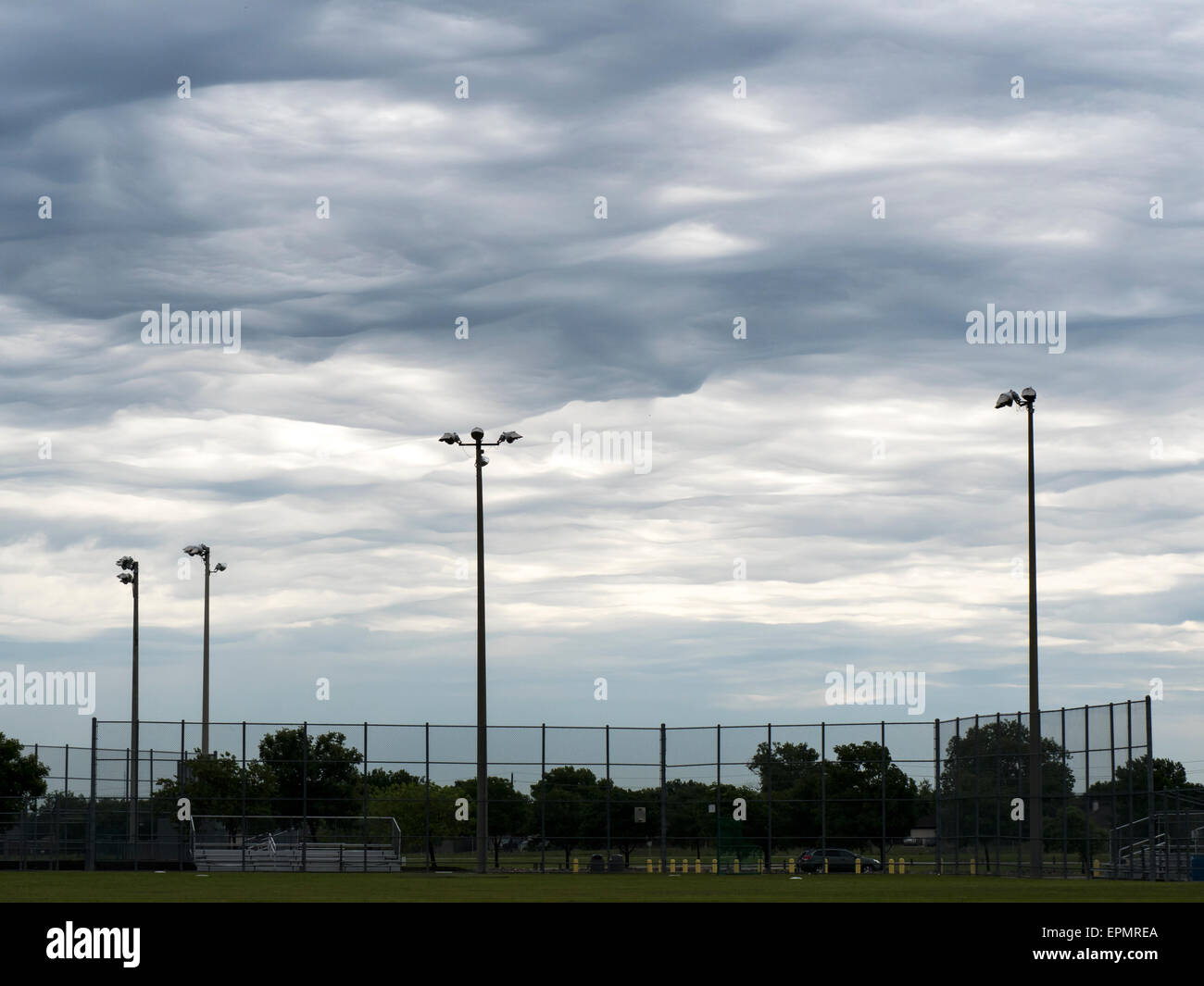 Pubblico Locale Ball Park con drammatica nuvole temporalesche in background Foto Stock