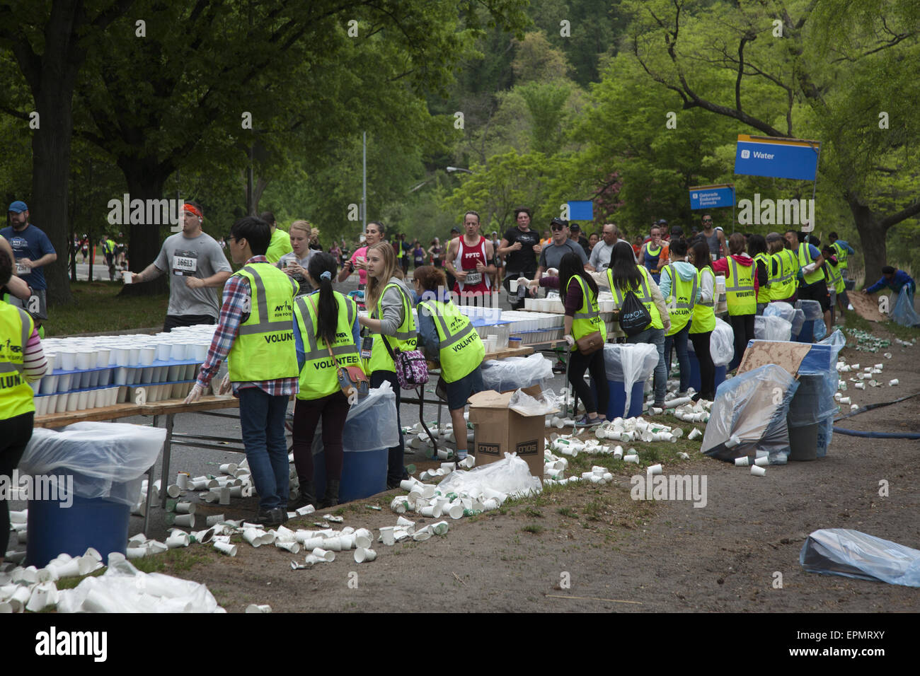 I volontari danno l'acqua per i corridori al Brooklyn ½ Maratona in Prospect Park al giro di boa della gara. Foto Stock