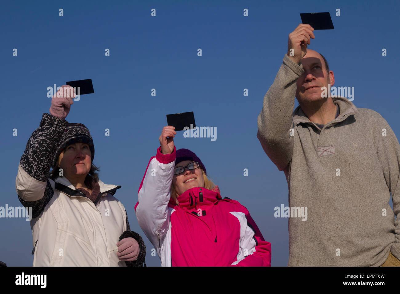 Persone che guardano la specacular parziale eclissi solare, XX marzo, 2015, sulla brughiera, Penisola di Gower, Wales, Regno Unito Foto Stock