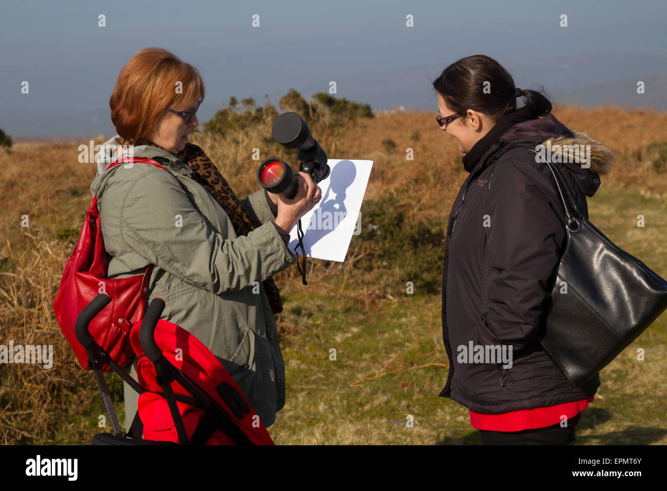 Persone che guardano la specacular parziale eclissi solare, XX marzo, 2015, sulla brughiera, Penisola di Gower, Wales, Regno Unito Foto Stock