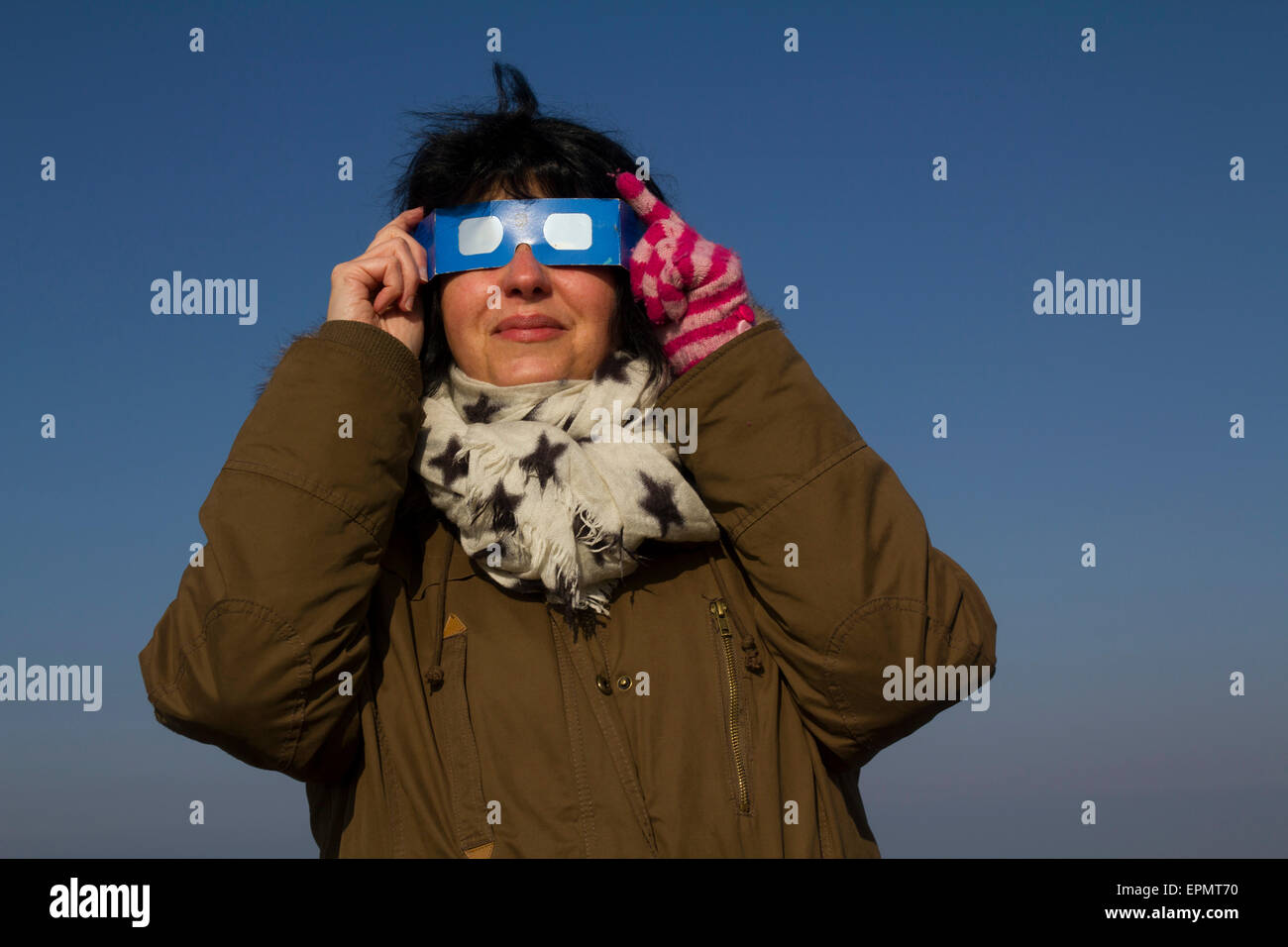 Donna guardando il specacular parziale eclissi solare, XX marzo, 2015, sulla brughiera, Penisola di Gower, Wales, Regno Unito Foto Stock