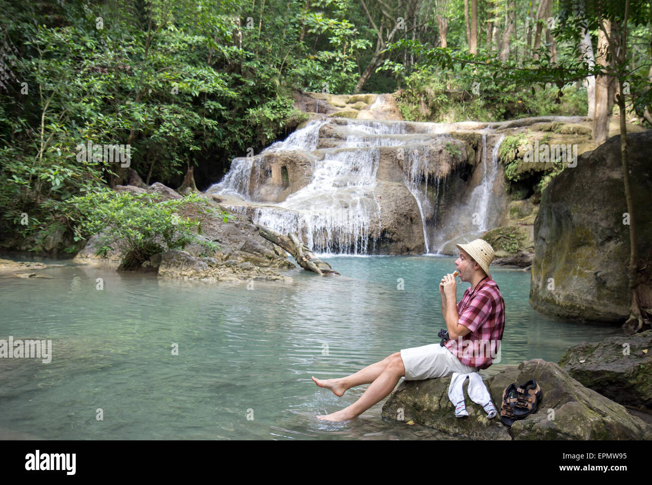 Appoggio turistico nei pressi di una cascata e mangiare toast Foto Stock