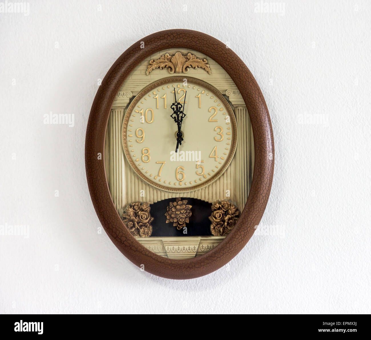 Orologio a pendolo appeso al muro bianco che mostra delle ore dodici Foto Stock