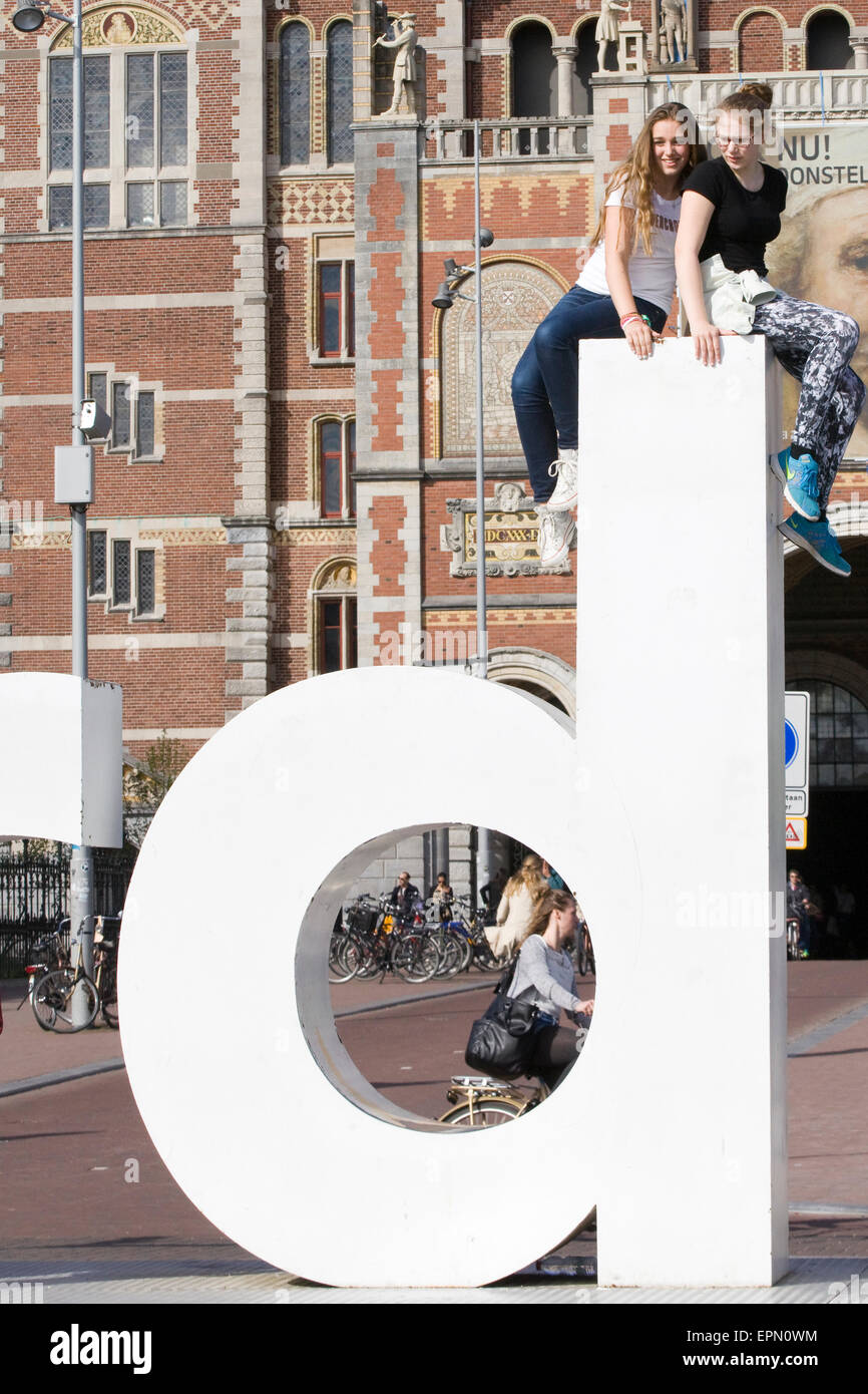 Due giovani ragazze seduto sulla Giant D sulla IAmsterdam scultura in Paesi Bassi Foto Stock