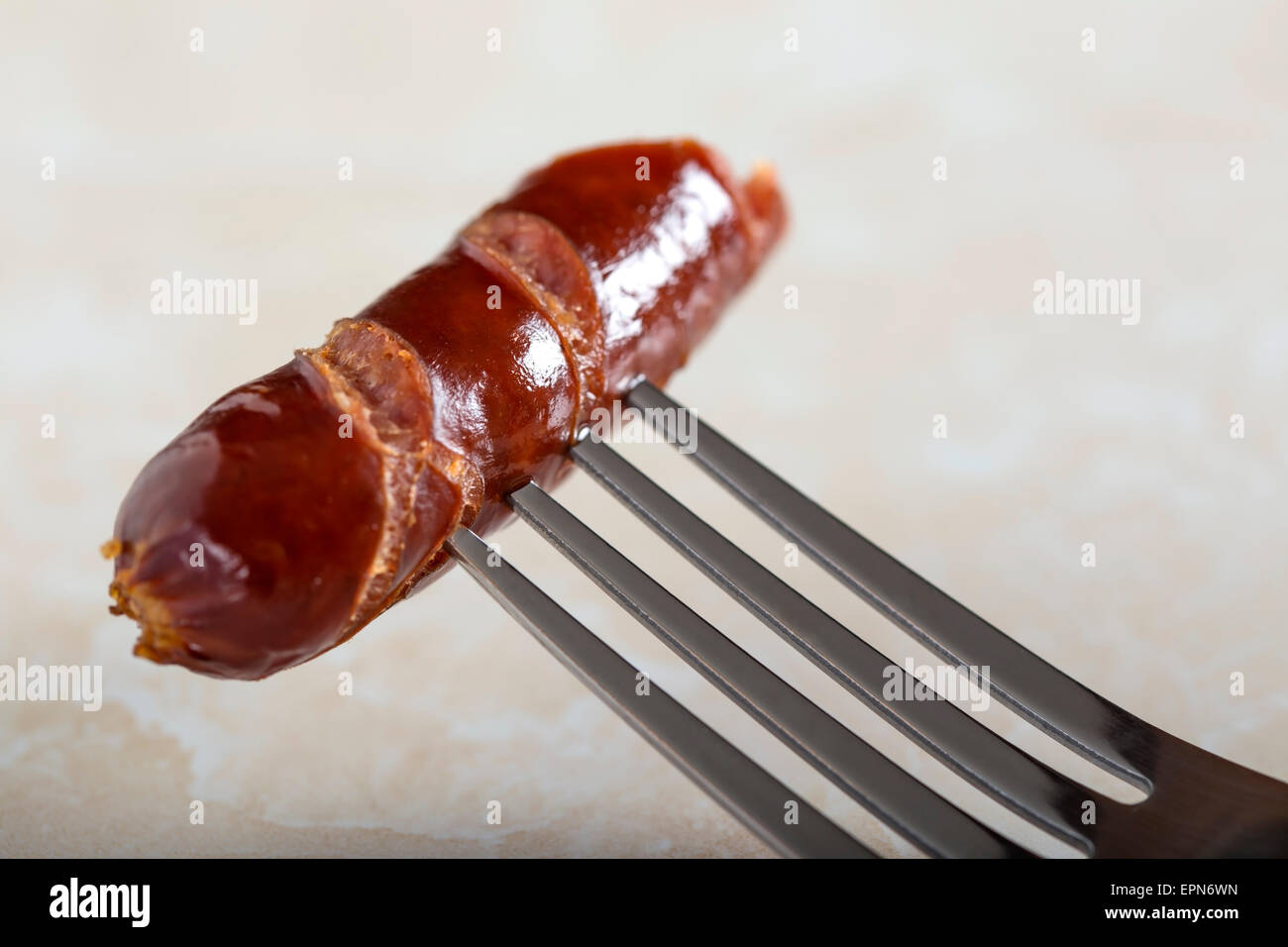 Salsicce alla griglia su una forcella con sfondo sfocato Foto Stock