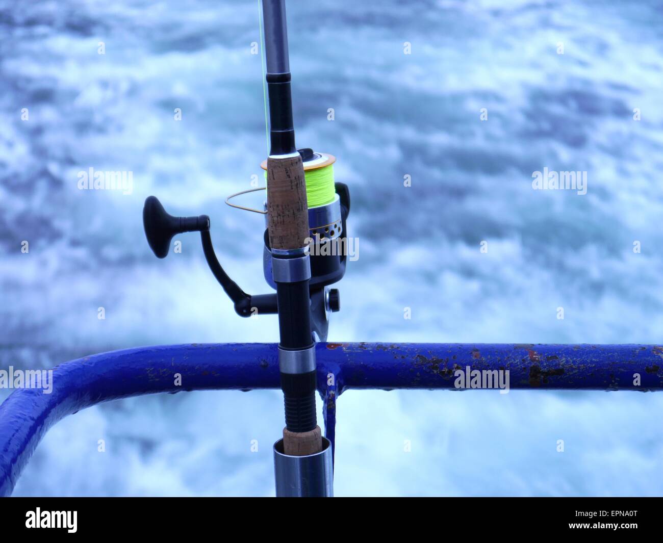 Canna da pesca a spinning-ruota su sfondo del mare Foto Stock