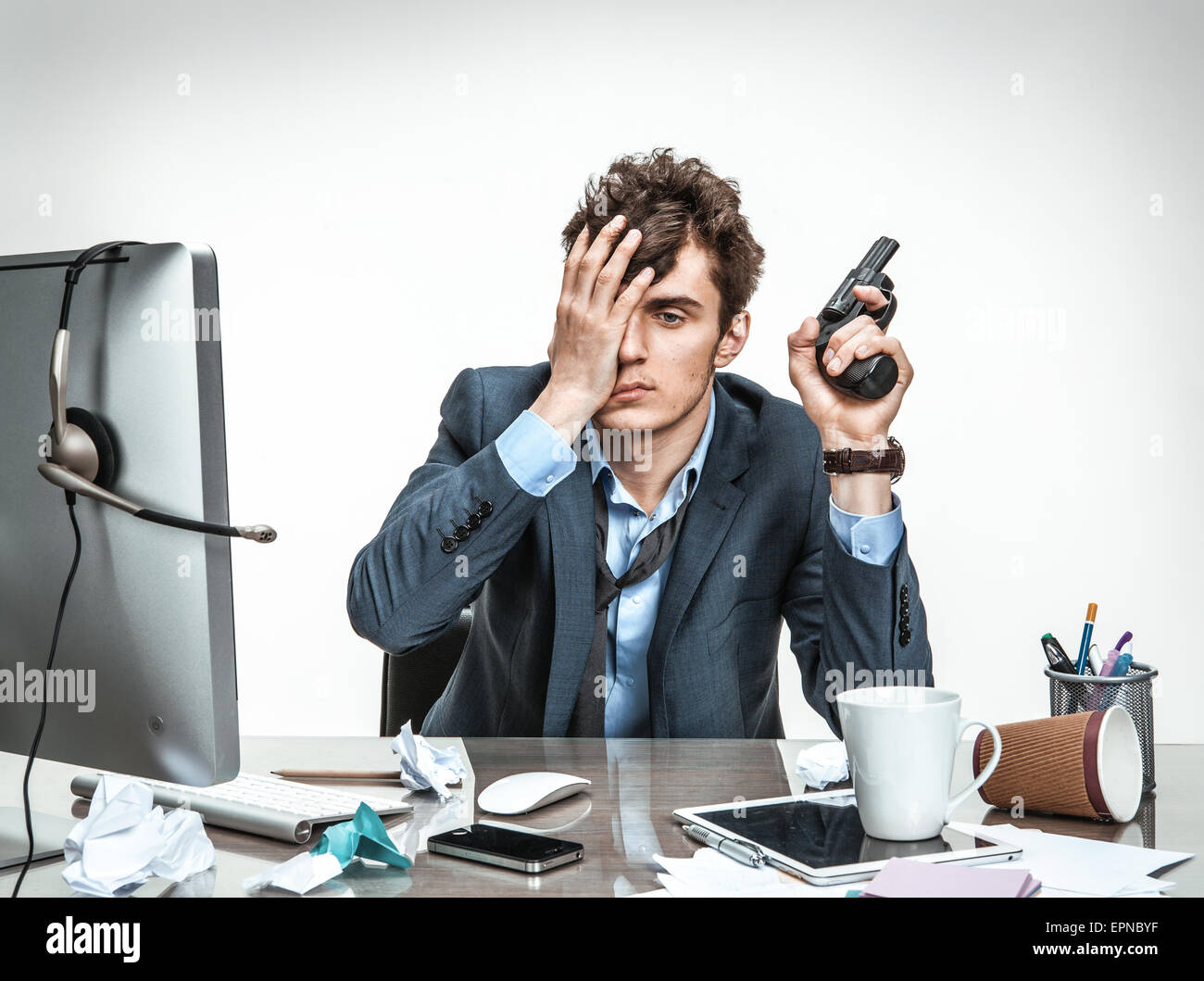 Cancelliere con la pistola vuole suicidarsi / ufficio moderno uomo al posto di lavoro, depressione e il concetto di crisi Foto Stock