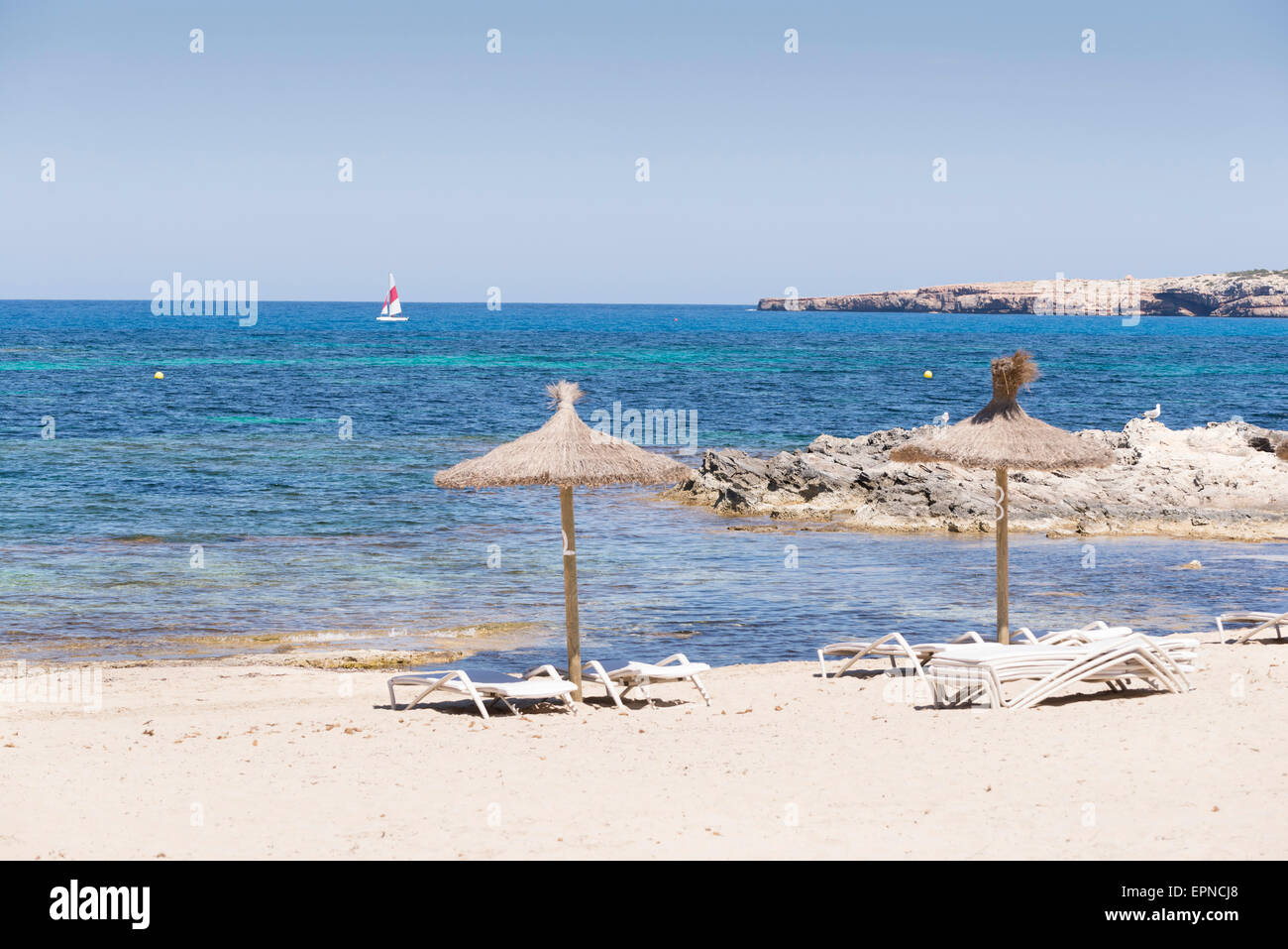 Spiaggia tropicale con alcuni ombrelloni di paglia in Formentera, Foto Stock