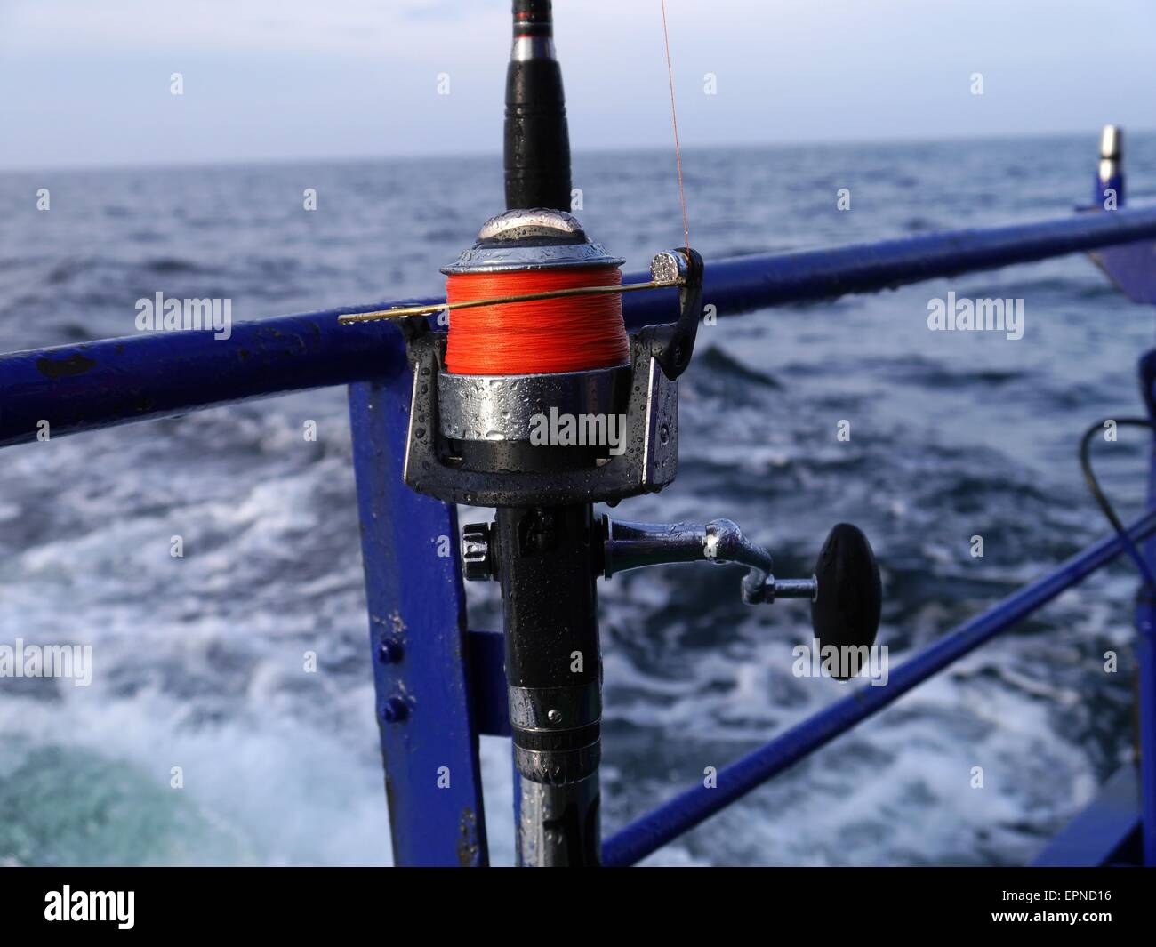 Canna da pesca a spinning-ruota su sfondo del mare Foto Stock