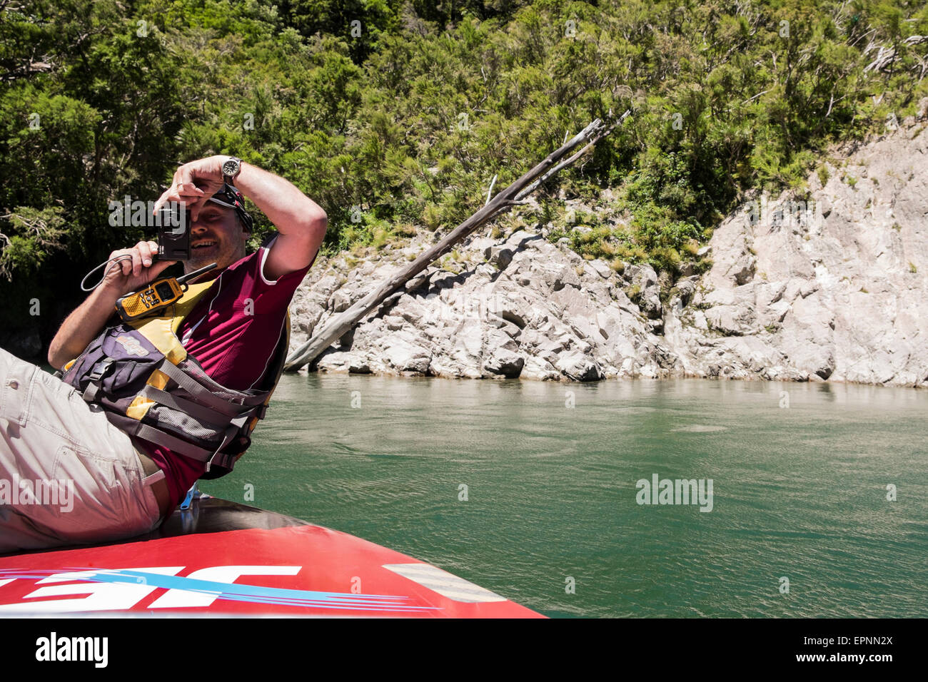 Buller Canyon jet boat driver sulla prua di scattare le foto dei suoi ospiti sul viaggio in barca, Murchison, Nuova Zelanda. Foto Stock