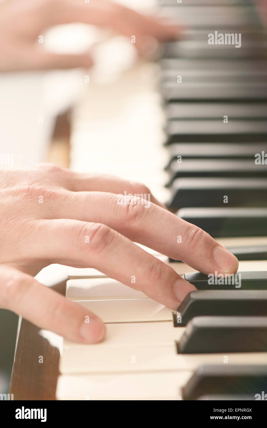 Close up delle mani dell uomo a suonare il piano Foto Stock