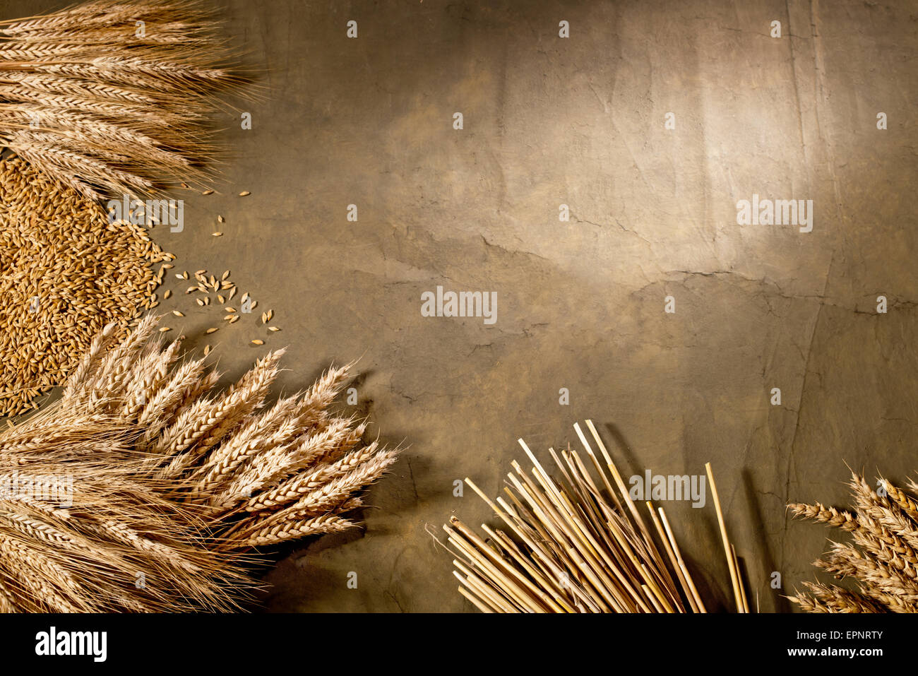 Un covone di grano ed orzo sulla scrivania scuro Foto Stock