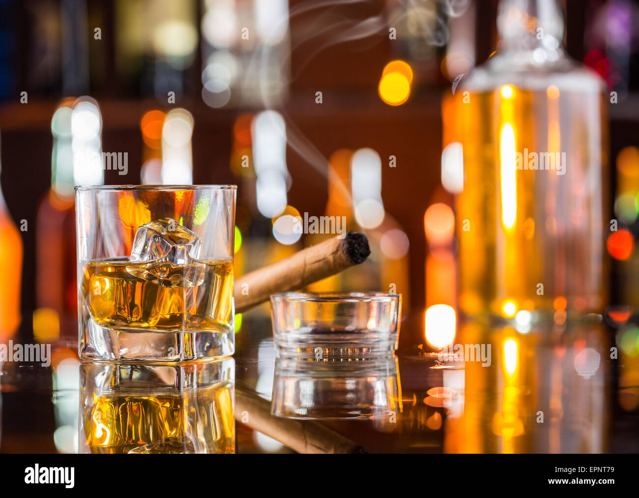 Whiskey drink con il fumo di sigaro sul bancone bar Foto Stock