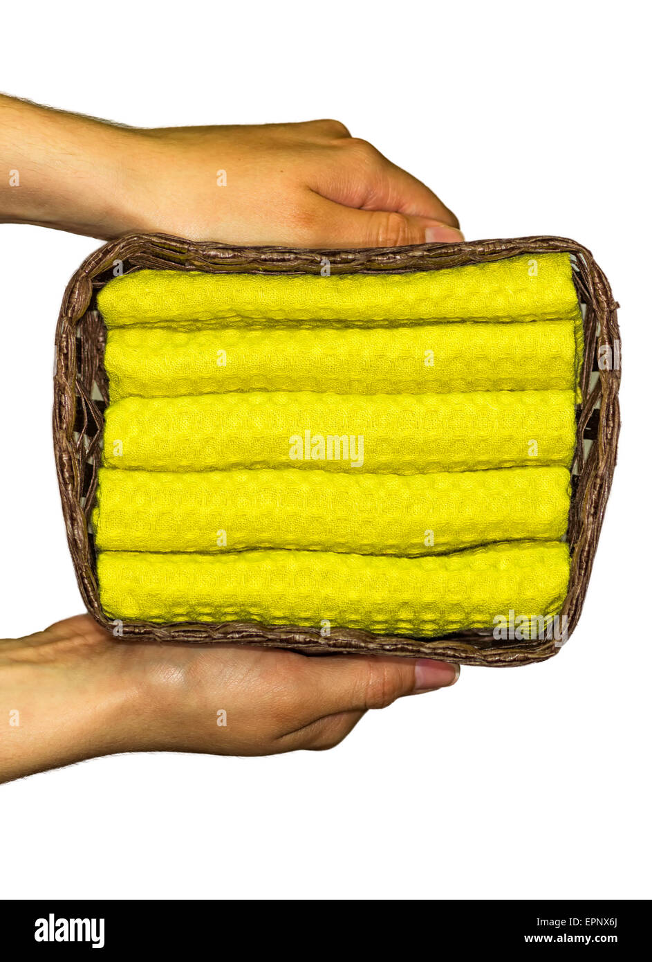 Mani femminili tenendo un cestello contenente gli asciugamani giallo Foto Stock