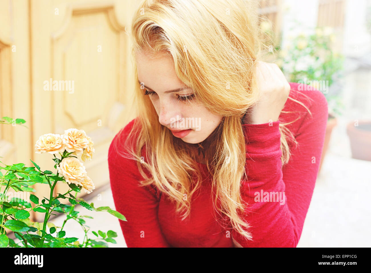 Ragazza giovane con lunghi capelli biondi, che ella tiene con la mano Foto Stock