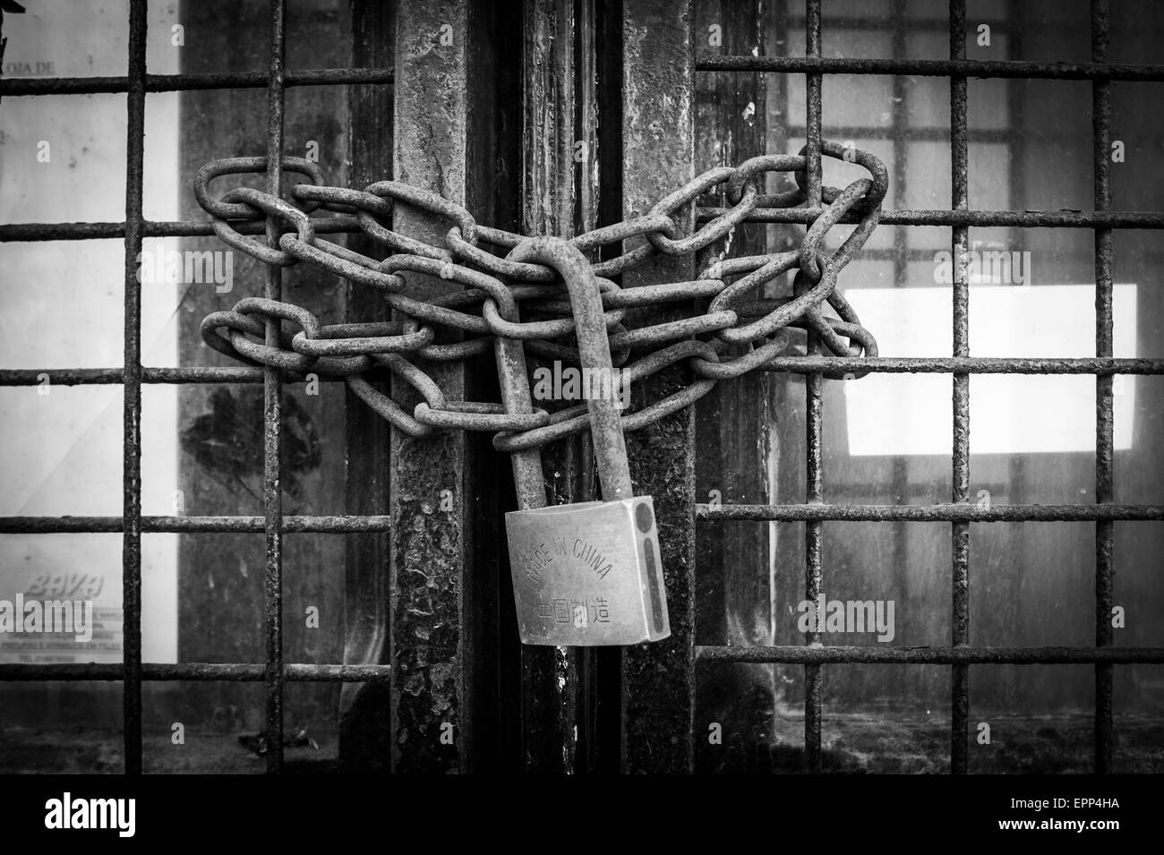 Rusty catena e lucchetto in ottone fissare una porta Foto Stock
