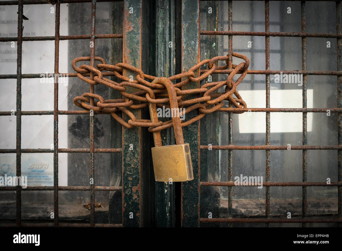 Rusty catena e lucchetto in ottone fissare una porta Foto Stock