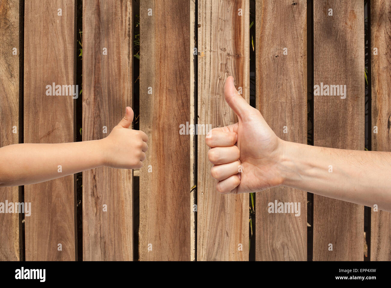Padre e figlio mani dando come sulla parete in legno sfondo. Foto Stock