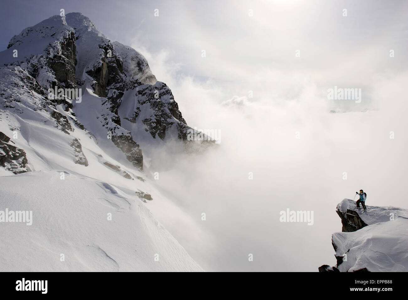 Sciatore guardando fuori sopra le nuvole e le montagne, British Colombia Foto Stock