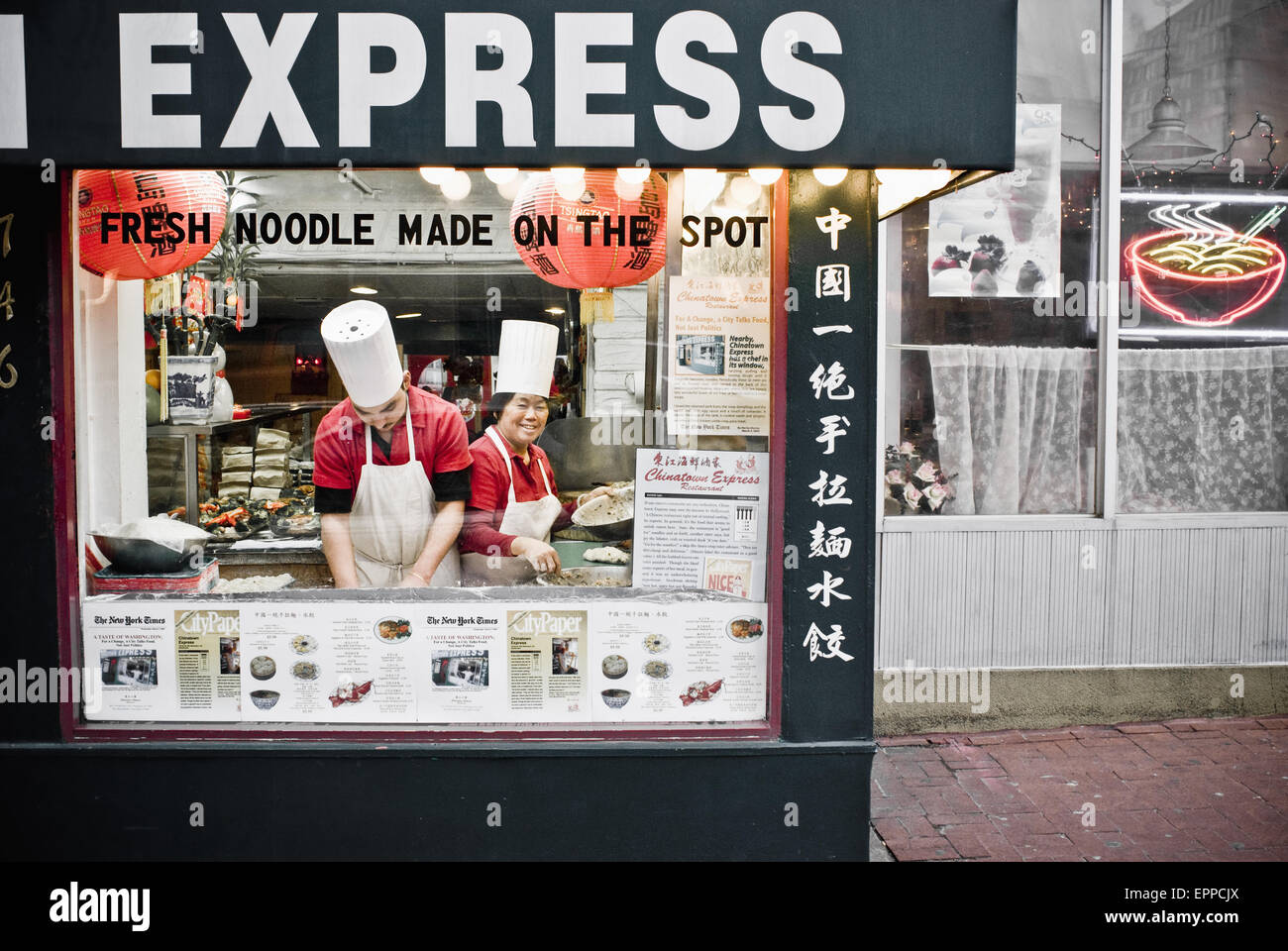 Due chef lavorano da una grande finestra di visualizzazione progettato per attirare gli spettatori. Foto Stock