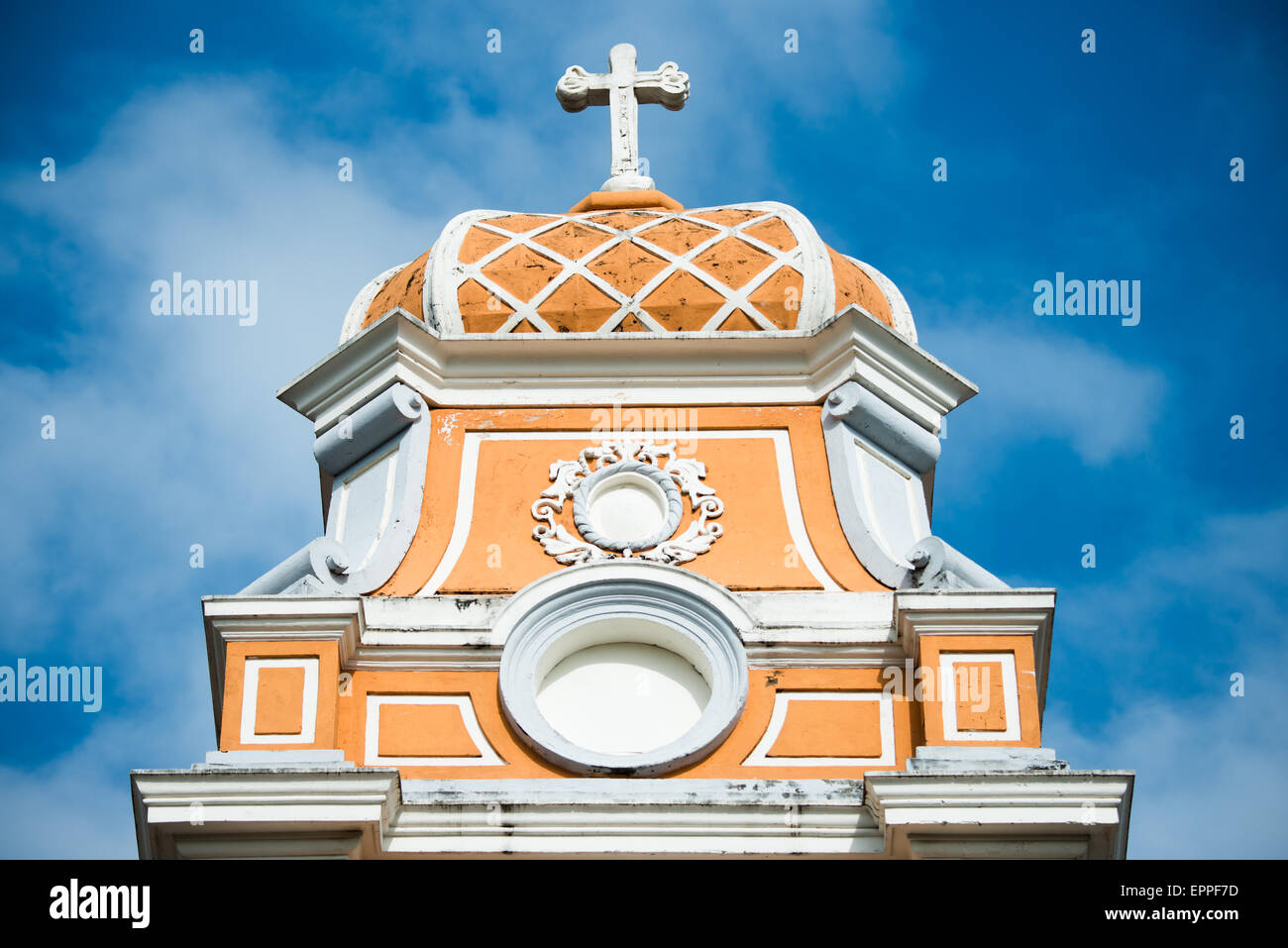Iglesia De Xalteva Campanile Granada Nicaragua // GRANADA, Nicaragua — il caratteristico campanile di Iglesia de Xalteva sorge sopra la storica città coloniale di Granada. Questa chiesa cattolica in stile barocco, conosciuta per la sua suggestiva facciata arancione e bianca, è una delle più antiche strutture religiose della regione. Iglesia de Xalteva è un importante punto di riferimento nel quartiere Xalteva di Granada, un'area che un tempo era il centro di una comunità indigena prima della colonizzazione spagnola. Gli elementi architettonici della chiesa mostrano la fusione di influenze europee e locali tipiche del re coloniale Foto Stock