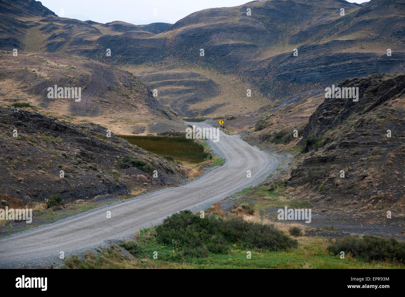 Un solitario strada di ghiaia nel Parco Nazionale Torres del Paine, Patagonia, Cile Foto Stock