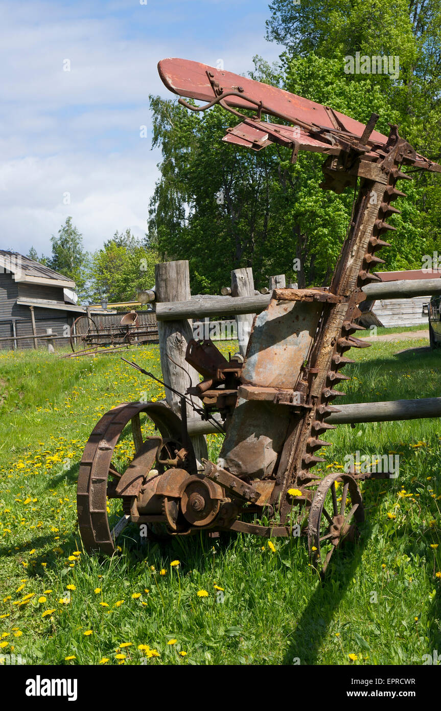 Rusty retrò macchine agricole Tosaerba di frumento dell inizio del ventesimo secolo. Soleggiata giornata di primavera paesaggio Foto Stock