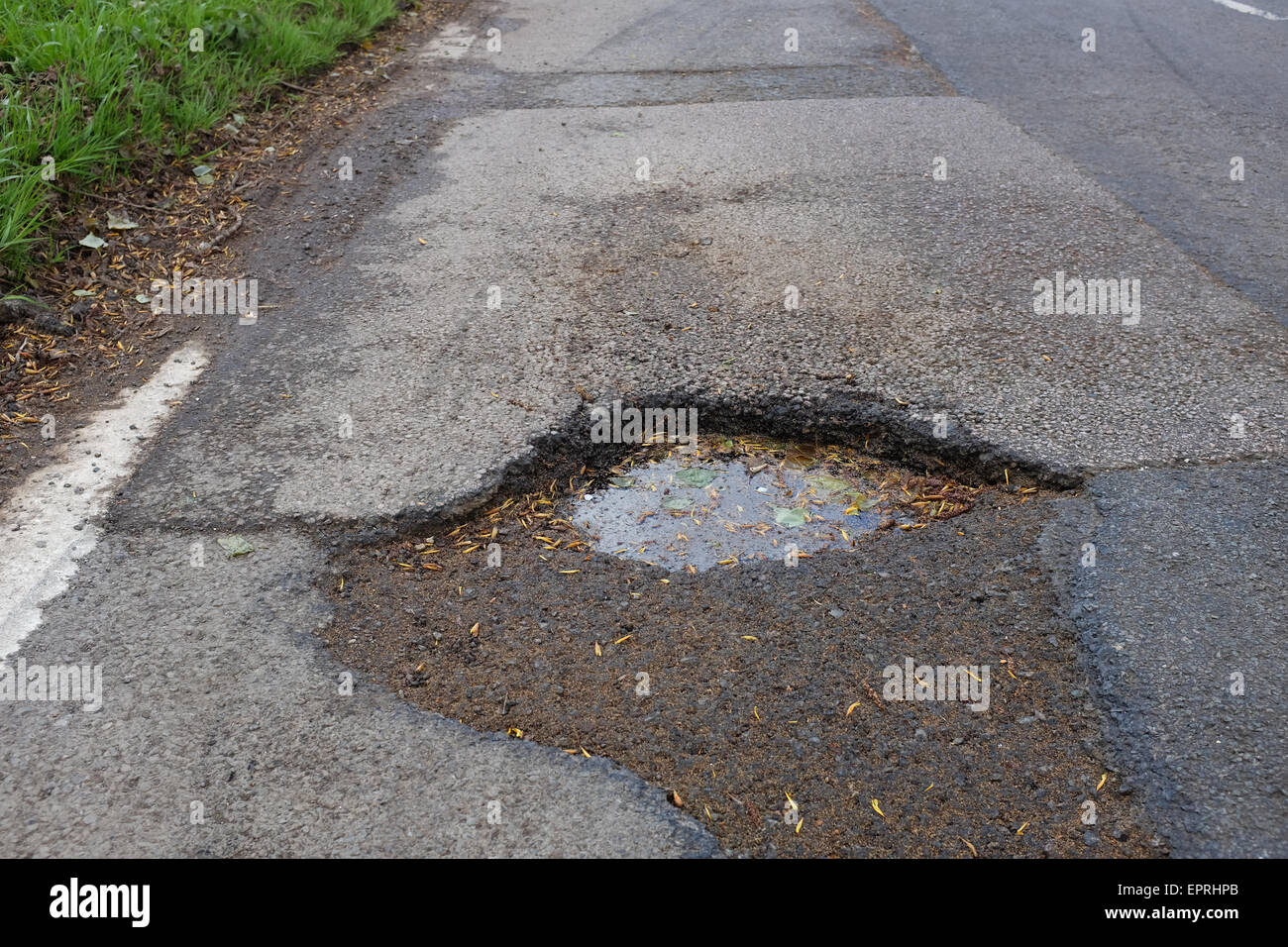 Una strada con una buca. Foto Stock