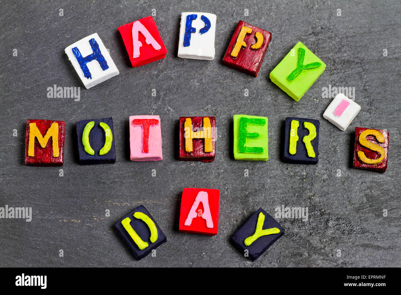 Felice Festa della mamma parole e cuori in pietra scura sullo sfondo Foto Stock