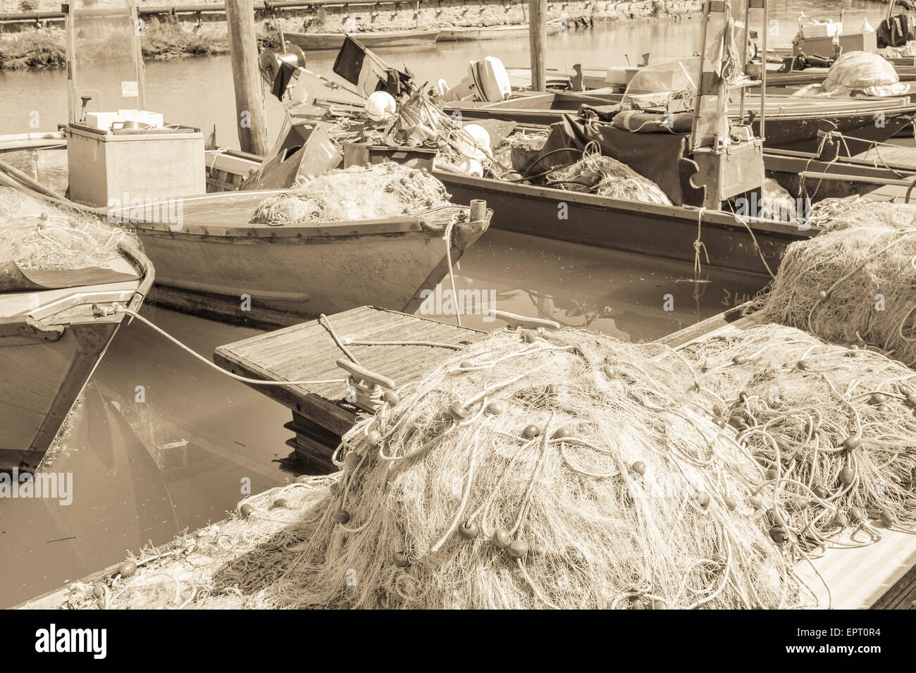 Effetto vintage reti da pesca in banchina, in background le barche da pesca Foto Stock