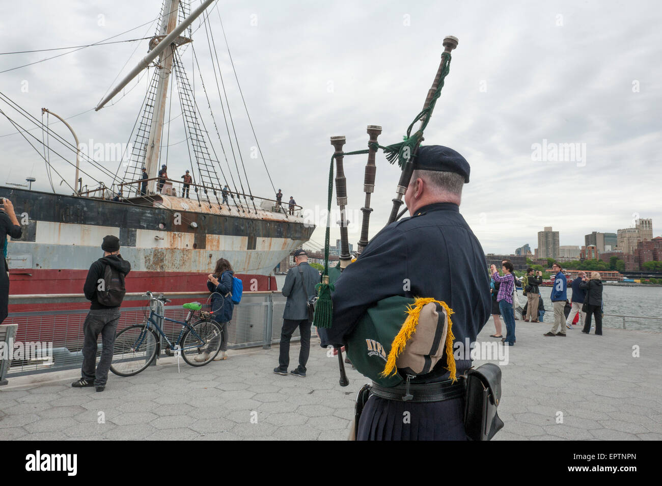 New York, Stati Uniti d'America. 21 Maggio, 2015. Daniel Sprague, un tubo sergent con tubi Tamburi & New York City del Dipartimento di Polizia di società di smeraldo, serenate il South Street Seaport Museum di nave, Wavertree, come rimorchiatori tirato il suo allontanamento dal Pier 15 nell'East River per il suo viaggio a Caddell il bacino di carenaggio in Staten Island. Wavertree, un ferro da stiro a scafo nave a vela, è stato costruito in Liverpool, in Inghilterra nel 1885 per servire come una nave da carico. Lei sta per subire un anno-lungo, $10.6 milioni di restauro e la stabilizzazione, il più grande progetto mai intrapreso negli Stati Uniti. Credito: Terese Loeb Kreuzer/Alamy Live Foto Stock