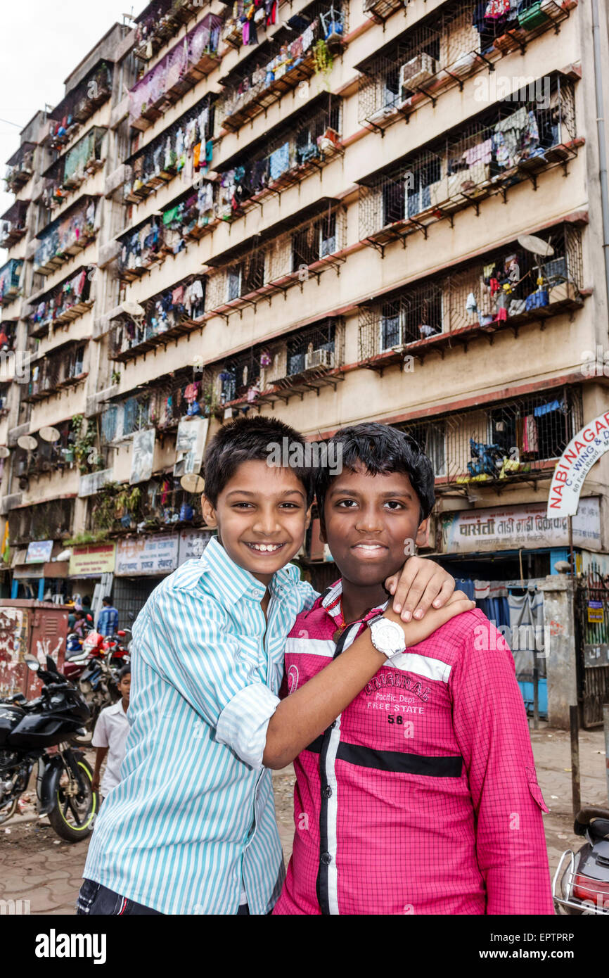 Mumbai India, Dharavi, 60 piedi strada, slum, poveri, basso reddito, poveri, povertà, ragazzi maschi ragazzi bambini amici bambini, alto aumento, edificio residenziale, lavanderia appeso Foto Stock