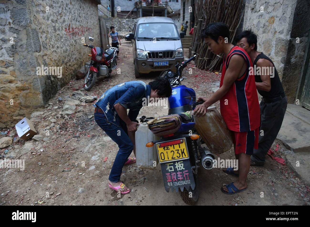 (150522) -- DAHUA, 22 maggio 2015 (Xinhua) -- Meng Guixin (seconda R) trasporta acqua a Nongyong villaggio di Bansheng township di Dahua Yao contea autonoma, a sud-ovest della Cina di Guangxi Zhuang Regione autonoma, 28 febbraio, 2015. Situato al centro del Carso landforms a ovest di Guangxi, Bansheng Township soffre di un grave deficit di acqua per età. Pertanto pioggia è una benedizione per le persone che vivono su questa terra per circa mille anni che sono principalmente di Yao gruppo etnico. Per soddisfare la loro vita quotidiana ha bisogno la popolazione locale sempre la raccolta delle acque piovane con tutte le dimensioni delle benne e barili, nonché una Foto Stock