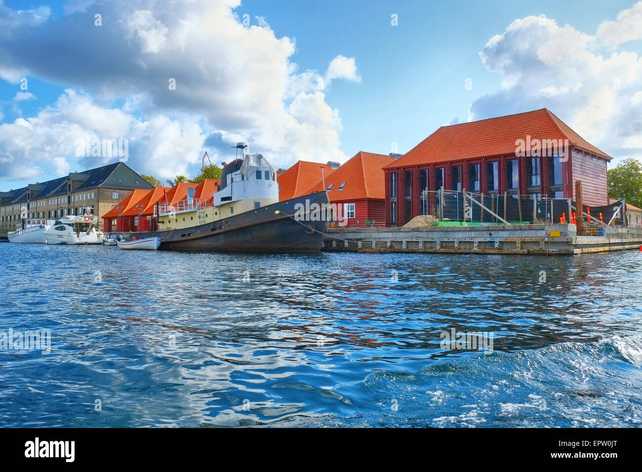 Le case con i tetti rossi e quaysidenear con una nave ormeggiata al porto principale ubicazione a Copenhagen, Danimarca. Foto Stock