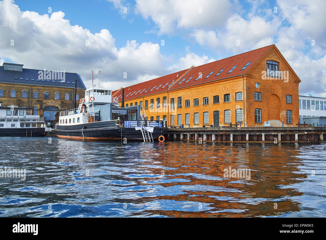 Le case con i tetti rossi e quaysidenear con una nave ormeggiata al porto principale ubicazione a Copenhagen, Danimarca. Foto Stock
