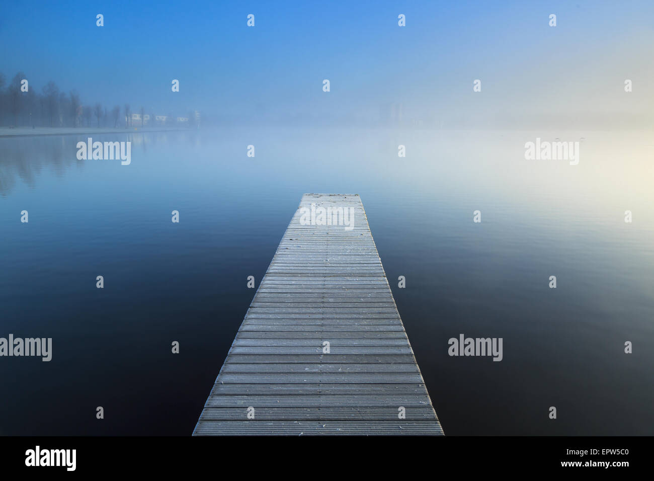 Svuotare jetty di brina in corrispondenza di un lago di nebbia durante un freddo sunrise. Foto Stock