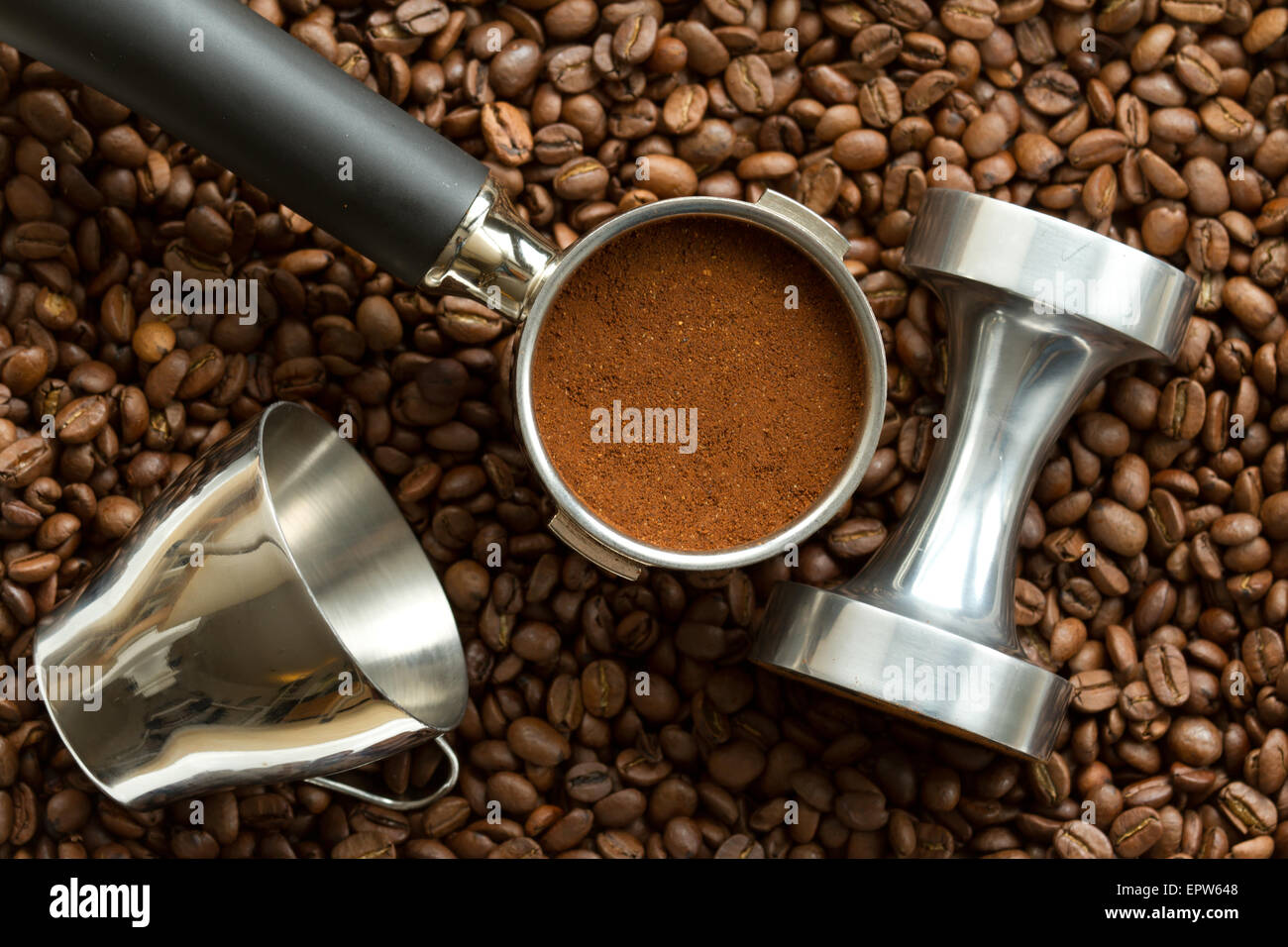 Pistone Espresso, chiamato anche portafilter, una manomissione e di un espresso in tazza di chicchi di caffè espresso. Foto Stock