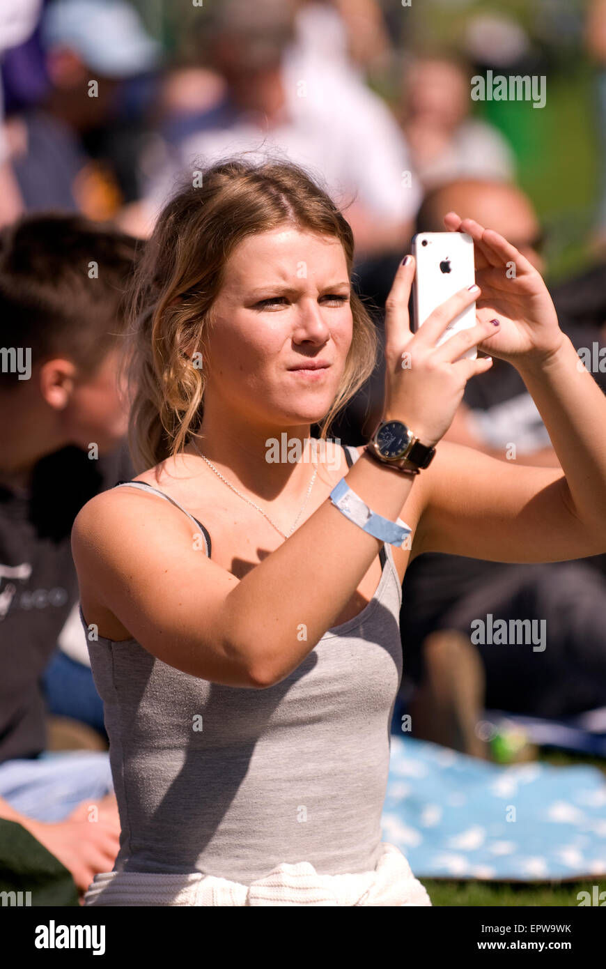 Giovani femmine tra la folla prendendo le fotografie sul suo iPhone di bande locali a un festival di musica (CHIDDFEST 2015), Surrey, Regno Unito. Foto Stock