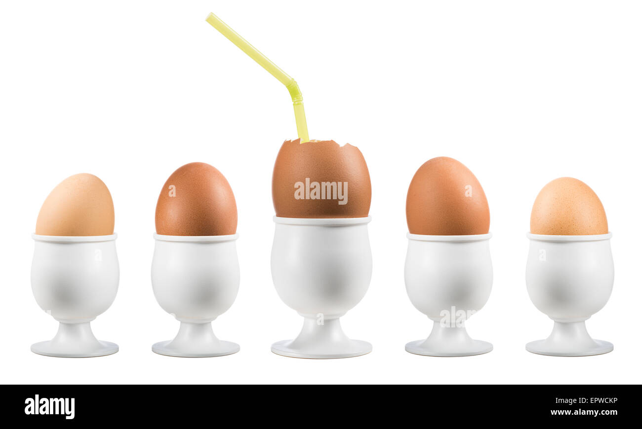 Uova su eggcup in una riga con una rotta su sfondo bianco Foto Stock