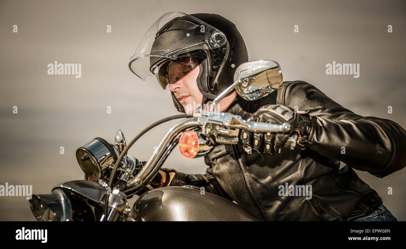 Biker in casco e giacca di pelle racing su strada Foto Stock Biker in casco e giacca di pelle racing su strada Foto Stock