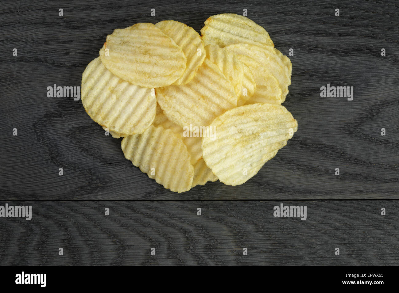 Increspata chip organico su un tavolo di legno Foto Stock