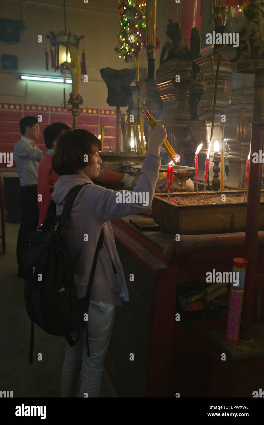 dh Man Mo Tempio SHEUNG WAN HONG KONG Cina donna Joss sticks tempio che prega cina taoismo tenere incenso bastone persone interne Foto Stock