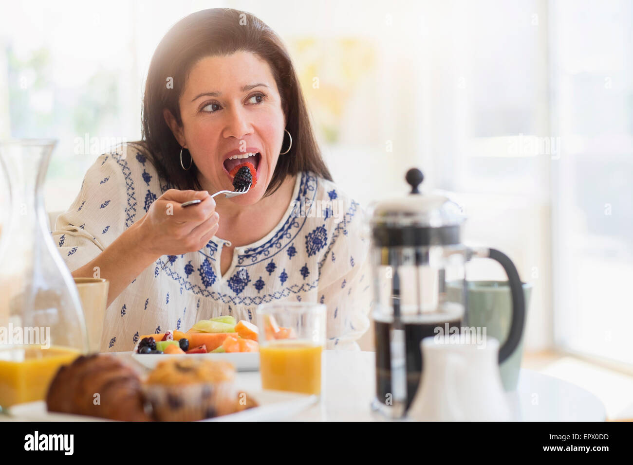 Donna di mangiare more per la prima colazione Foto Stock