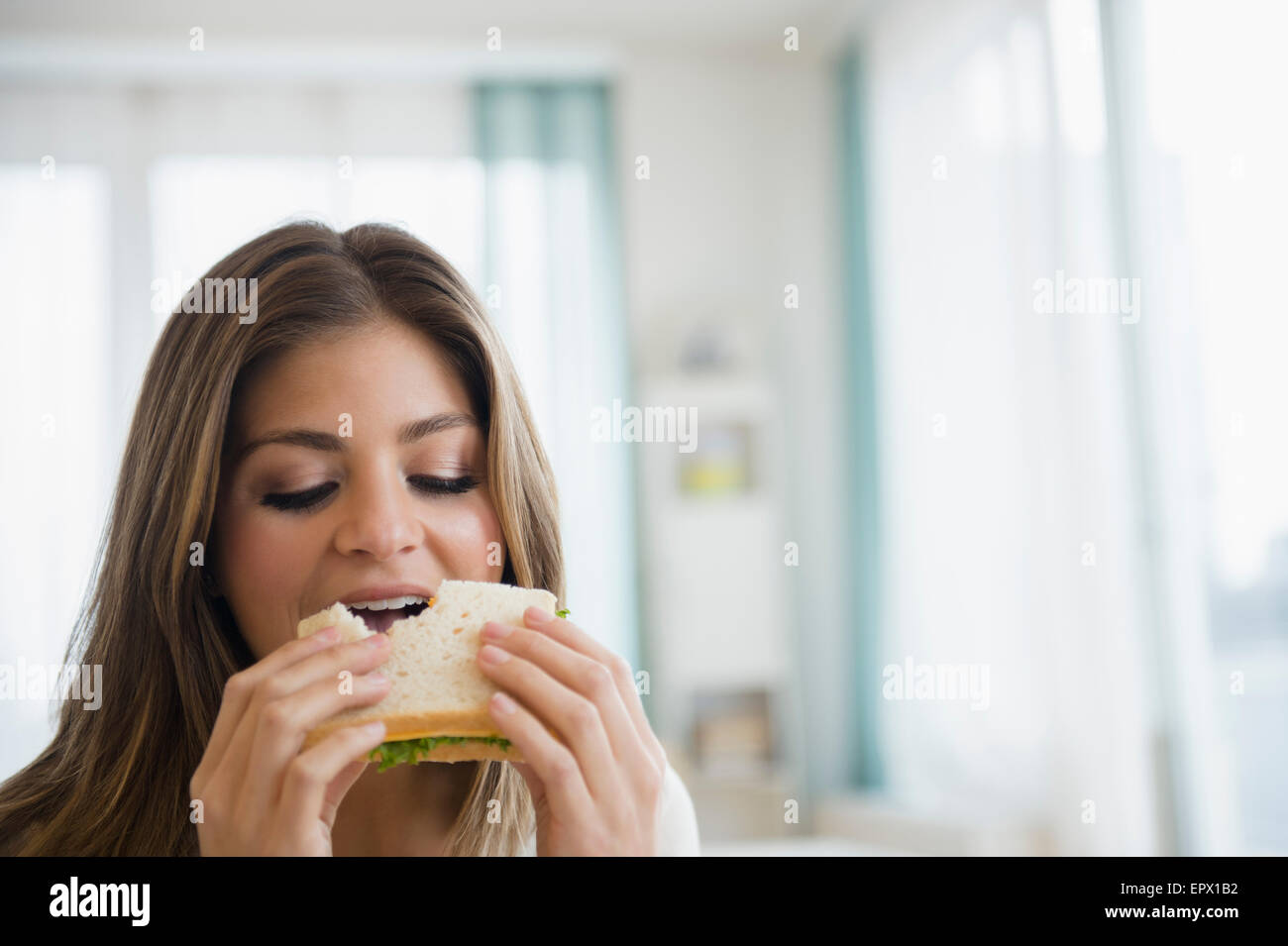 Giovane donna mangiare panino Foto Stock