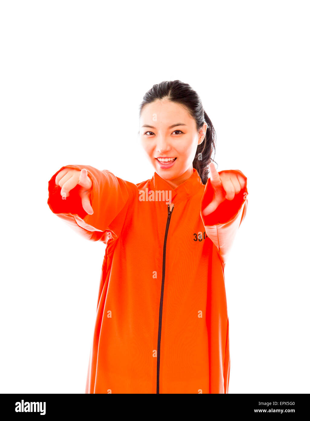 Giovane donna asiatica rivolta verso la telecamera con entrambe le mani in uniforme dei prigionieri Foto Stock