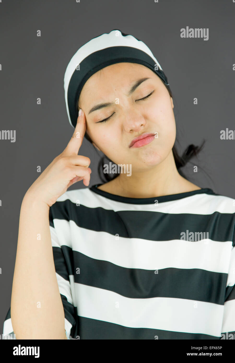 Giovane donna asiatica pensando in uniforme dei prigionieri Foto Stock