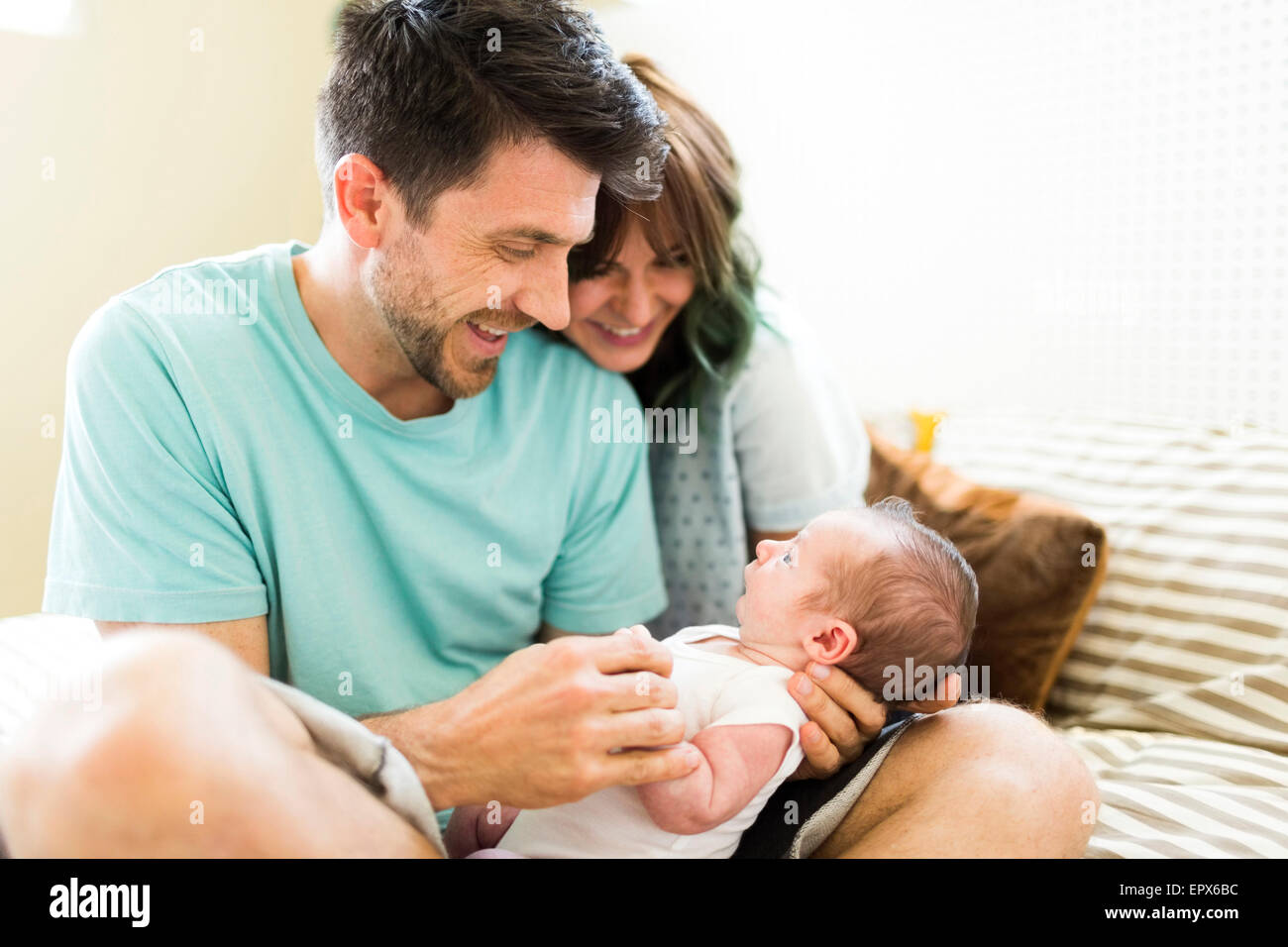 Genitori felici guardando baby boy (6-11 mesi) Foto Stock